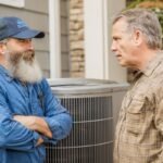 Technician and homeowner discussing the outdoor unit while considering ac replacement cost.